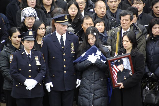 Liu's widow Pei Xia Chen, holding the police flag from his casket<br/>